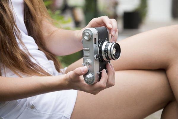 girl holding vintage camera outdoors