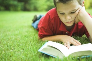 boy-reading-book-outside