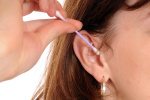 Eine junge Frau reinigt sich die Ohren / A young woman cleans her ear